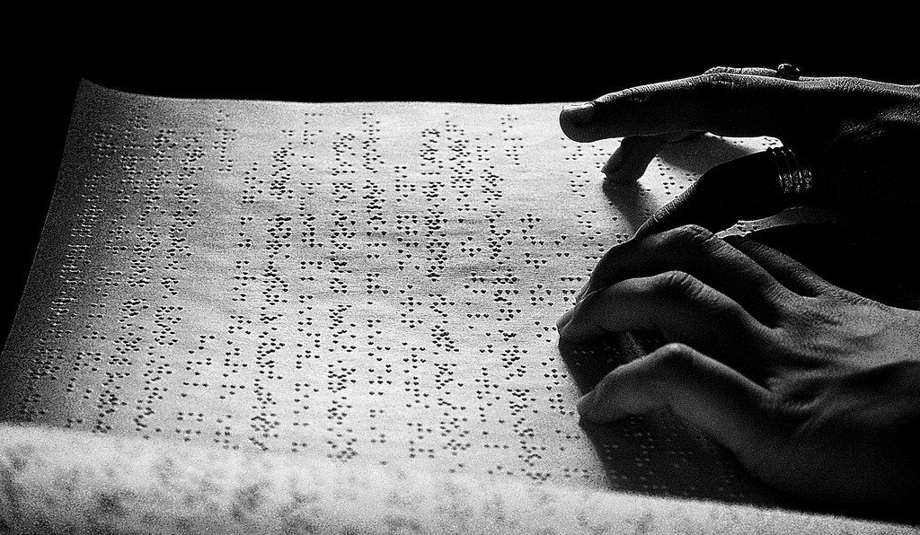 A page of Braille text is being read