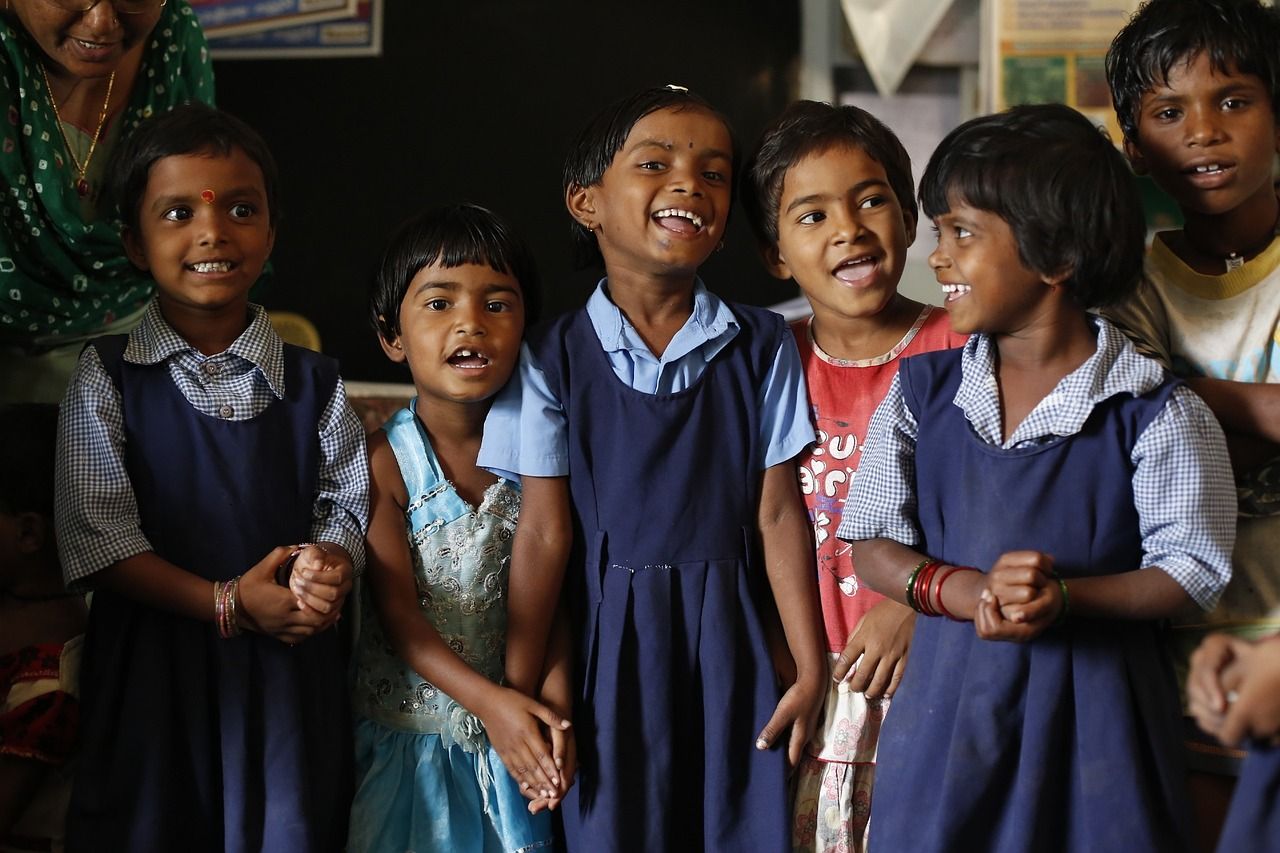 Several girl children are seen in blue uniforms