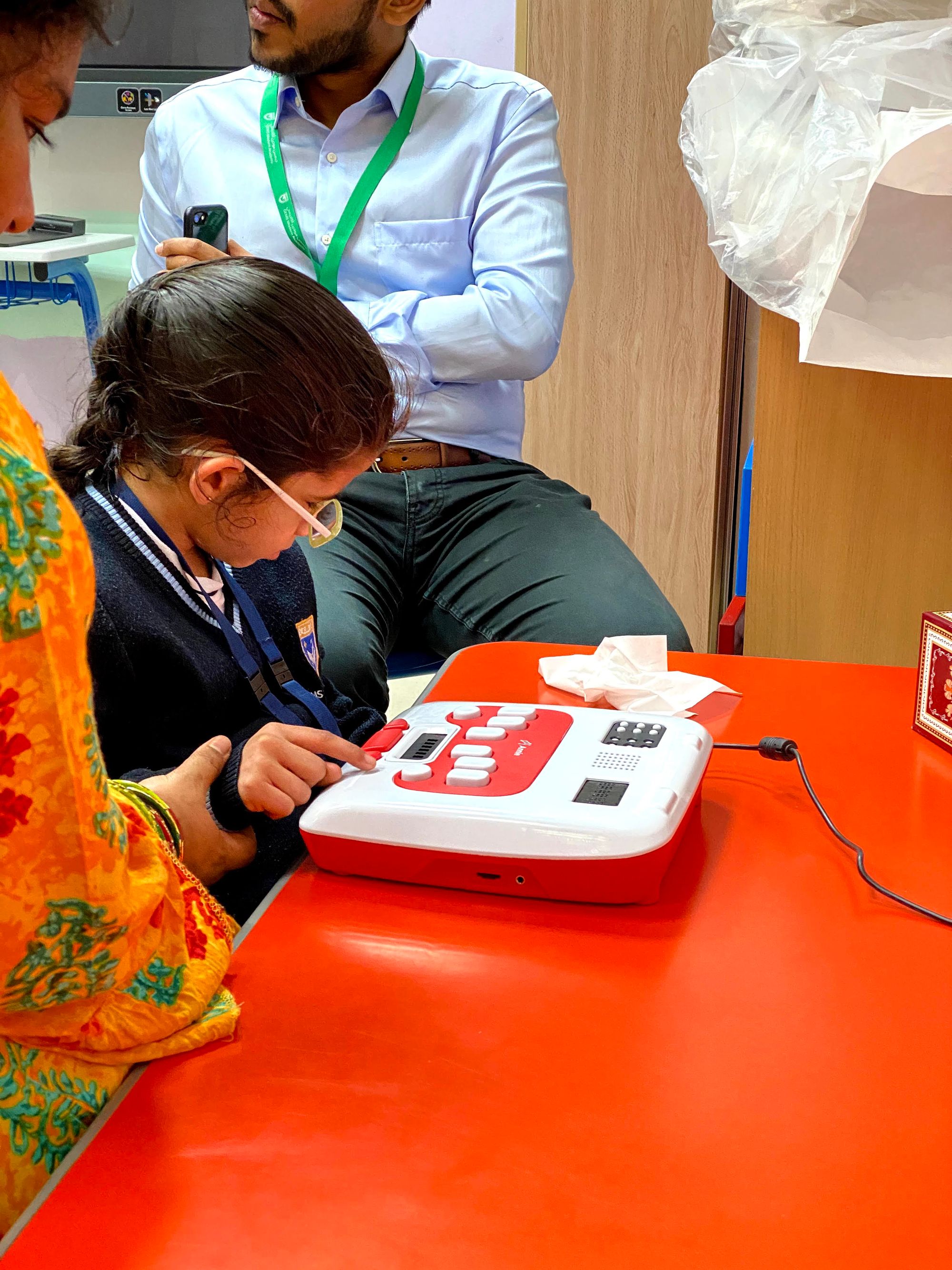 A teacher guides her student's use of the Annie Braille self-learning device