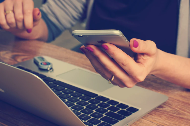 A woman uses her laptop and cellphone