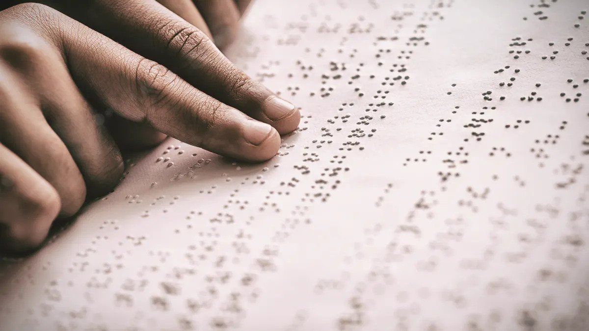 A person is reading Braille with their two index fingers