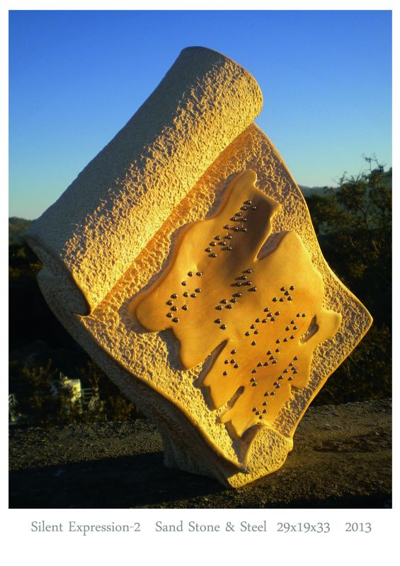 A terracota sculpture that resembles a clay tablet at a 45 degree incline to the ground. The tablet has Braille text stuck to it