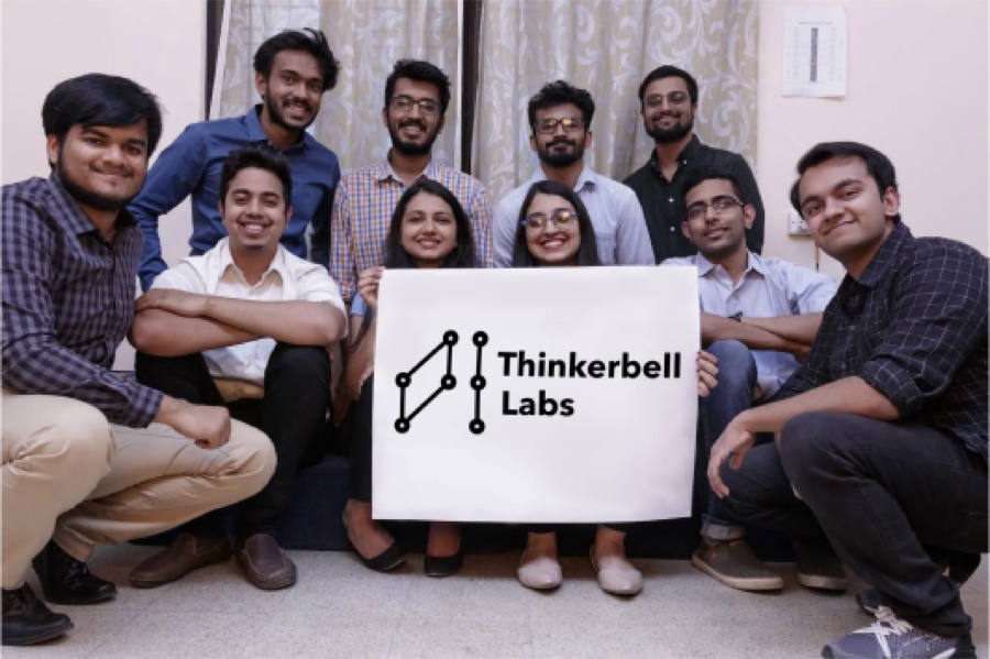 The Thinkerbell Labs team holding a company sign.