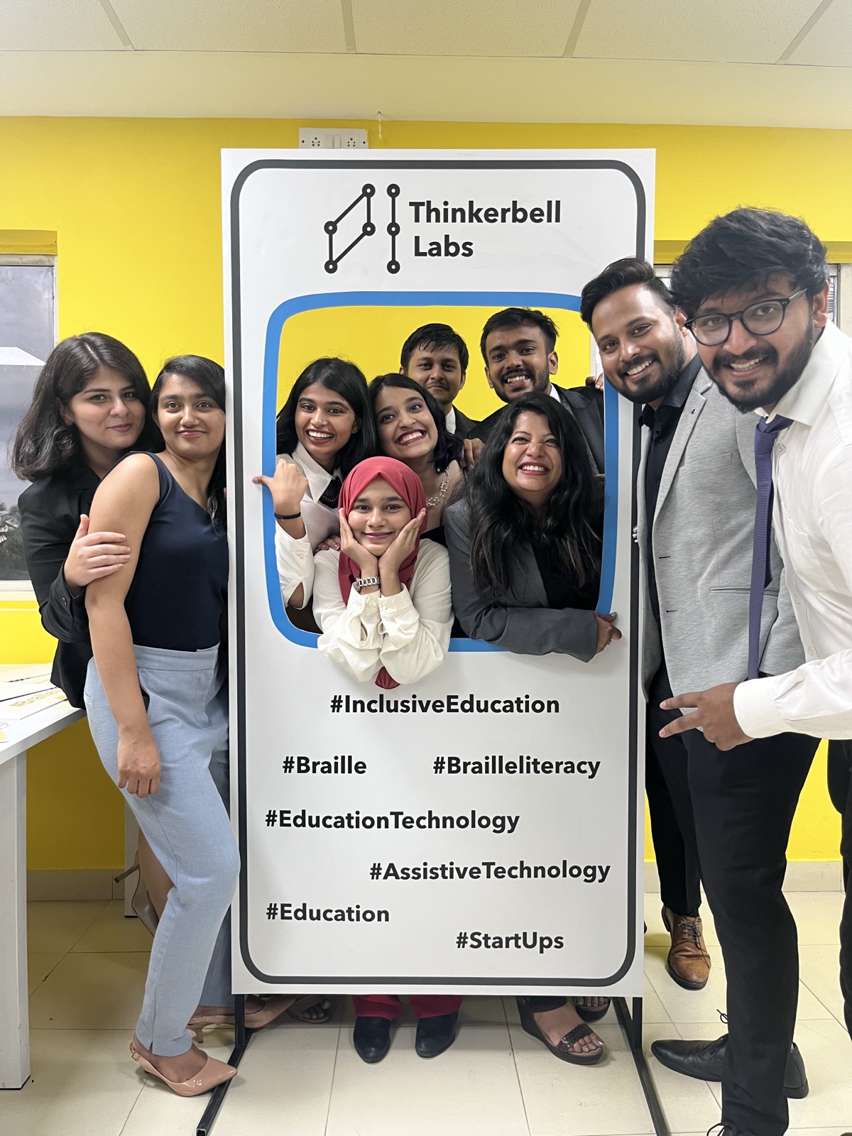 The Thinkerbell Labs team crowded around a branded photo frame in the office.